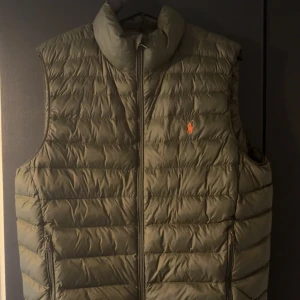 Olivgrön dunväst från Polo Ralph Lauren - Olivgrön dunväst från Polo Ralph Lauren i storlek M. Säljer den då den inte kommer till användning och är för stor.