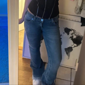 True Religion blå bootcut jeans - Säljer ett par blå jeans från True Religion med klassisk kontrastsöm och ikonisk broderad ficka bak. Modellen har bootcut-ben och låg midja, tillverkade i mjukt denimtyg. Storlek W29 Använda 3/4 gånger  Säljer då de är lite stora Jag är 168cm för referens