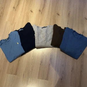 Ralph Lauren stickade tröjor i olika färger - Fem stickade tröjor från Ralph Lauren i blått, marinblått, beige, brunt och ljusblått. Klassisk rund halsringning och broderad logga på bröstet. Perfekta för lager-på-lager och snygga till jeans eller chinos.