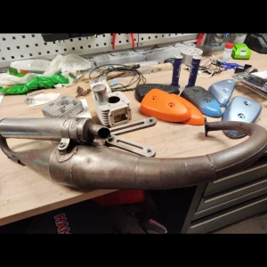 Avgassystem och cylinderkit till moped - Säljer ett komplett avgassystem och cylinderkit till moped. Delarna är i begagnat men bra skick, med endast mindre ytliga repor och normalt slitage. Perfekt för dig som vill uppgradera eller reparera din moped. Flera kåpor och handtag ingår.
