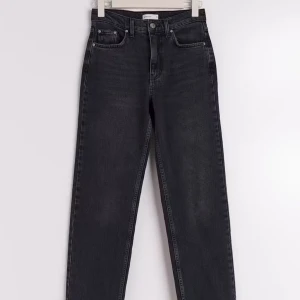 Svarta raka jeans från Gina - Säljer ett par svarta jeans med raka ben. Jeansen har klassisk femficksdesign och stängs med knapp och dragkedja. Materialet är jeans och färgen är en mörk tvättad svart. Perfekta för en clean och stilren look.