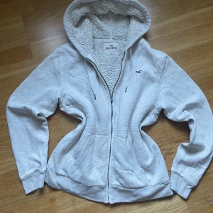 Vit hollister Y2K med foder Storlek M  - Säljer denna fantastiska vita Hollister tröjan i storlek L men passar M. Den har förminskat i tvätten!   - Passar perfekt för en Y2K look, stilig inför kyligare väder.   - Tröjan är i väldigt bra skick!  Vid fler frågor är det bara att