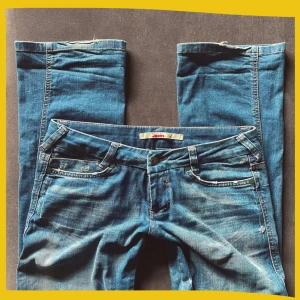 Lågmidjade bootcut jeans - Säljer dessa äkta vintage jeans från 90-talet!😍 De har varit älskade så därav några få märken som syns på bilderna, men i sin helhet är de superfina!✨Älskar dessa verkligen men tycker tyvärr de är lite långa på mig…                      Innerbenslängd: 85cm,   Midjemått (rakt över): 41cm