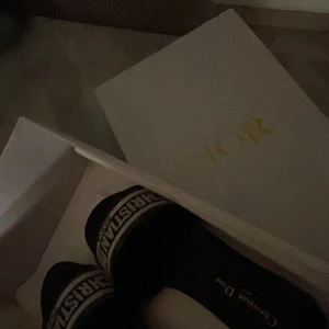 Svarta sandaler från Christian Dior - pris kan du diskuteras. Snygga svarta sandaler från Christian Dior med bred rem där loggan är broderad i vitt. Skorna har platt sula och öppen tå, perfekta för sommaren. Klassisk och trendig design som lyfter varje outfit. Skriv för mer bilder