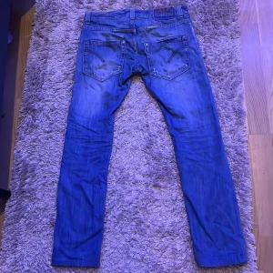 Ljusblåa Dondup Jeans  - Snygga Dondup jeans för billigt pris. De är i väldigt bra skick utan defekter. Slitningarna är en del av designen. Kan sänka pris vid snabb affär. 