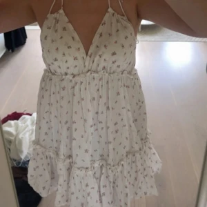 Vit klänning med blommor från HM - En vit klänning med blommor, öppen rygg och halterneck variant från HM! Jättefin till sommaren! En väldigt basic klänning men också en klänning som passar till det mesta❣️