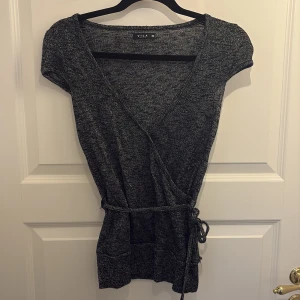 Omlott topp - Tunt stickad glittrig topp köpt second hand men från vila! Storlek XS men passar S också. 