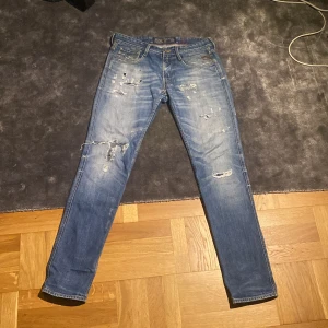 Blå Replay jeans med slitningar, 32/34 - Säljer mina riktiga feta Replay anbass med slitningar!! Jag säljer dem då dem inte riktigt passar mig och är inte min stil👖.              Slitningarna är välgjorda och väldigt snygga samt detaljerna på bakfickorna🙌🏽🙌🏽 Tyvärr har dem ett hål under dragkedjan. (Se bild 5)                           Tveka inte att ställa frågor eller be om hjälp med något🎉😉