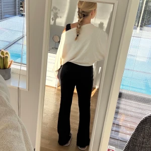 Svarta utsvängda mjukisbyxor - Svarta mjukisbyxor med ribbad struktur och snörning i midjan. Från Nelly i storlek s. 