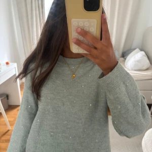 Ljusgrå stickad tröja med pärlor H&M - Superfin ljusgrå stickad tröja från H&M i storlek XS. Tröjan har små pärlor över hela framsidan som ger en extra touch. Mjuk och skön med ribbade muddar vid hals, ärmslut och nederkant. Perfekt för kyligare dagar!