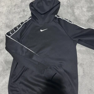 Svart Nike hoodie med vita detaljer - Säljer en Nike hoodie i storlek XS. Använd 2 gånger! Vid frågor så ställ gärna!!