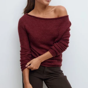 Vinröd offshoulder stickad tröja - Mysig vinröd stickad tröja med offshoulder-design och långa ärmar. Tröjan har en avslappnad passform och är perfekt för dig som gillar en enkel men snygg look. Materialet är mjukt och passar bra till både jeans och kjol.