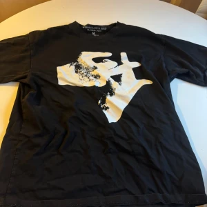 Playboi Carti Whole Lotta Red t-shirt - Svart t-shirt med vit  grafisk print framtill och bak, samt texten 'WHOLE LOTTA RED PLAYBOI CARTI' på ryggen. Skön passform och klassisk crewneck. Perfekt för dig som gillar streetwear och rapkultur.