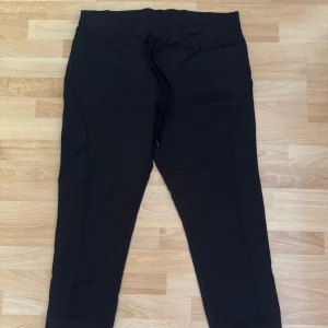 Nya. Svarta sport leggings med snörning - Svarta sport leggings med resår och snörning i midjan. Byxorna har ribbade muddar vid bensluten och är tillverkade i ett mjukt material som känns skönt mot huden. Perfekta för chill eller träning.