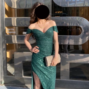 Dressroom linne balklänning  - Säljer en glittrig off shoulder emerald grön balklänning som köptes för 4500 kr. Jag är ca 160 cm lång och har extremt höga klackar som gjorde mig ca 170 cm lång under balen. Klänningen är i mycket god skick och har endast använts en gång (under balen 2025) ❤️