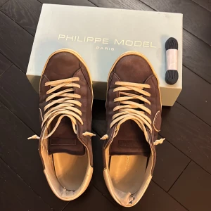 Philippe Model sneakers i mocka - Säljer dessa Philippe model skor i färgen blå. Skorna är köpt i april 2024 men har använts till juni 2025 sen har de blivit för små. Som ni kan se på bilderna är hälen och undersidan av skon lite trasig men går att fixa. Om ni har några frågor eller funderingar så är det bara att skriva👍 Pris kan diskuteras. Skorna är storlek 44 men passar även lite större storlekar.