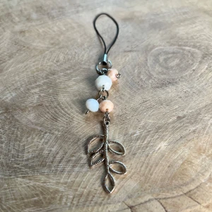 Väsksmycke  - Väsksmycke/phone-charm av glaspärlor och rostfritt stål🎀⚪️💍