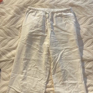 Vita linnebyxor med snörning - Säljer ett par vita linnebyxor med avslappnad passform och med snörning. Byxorna har raka ben och är perfekta för varma dagar. De är tillverkade i svalt linnematerial och har fickor i sidorna. Kan även såklart strykas. Priset kan diskuteras!💕