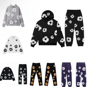 Grå hoodie med vita blommor - Grå hoodie med stora vita blommor tryckta över hela tröjan. Tröjan har huva, magficka och ribbade muddar. Perfekt för dig som gillar streetwear och vill sticka ut med ett coolt blommönster. Storlek: S och M 