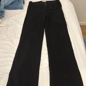 Svarta kostymbyxor med wide fit - Snygga svarta kostymbyxor med vida ben och klassisk passform. Från Nelly 