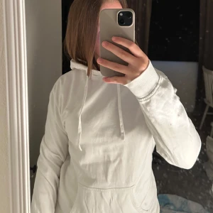 Vit hoodie med huva och ficka - Säljer en stilren vit hoodie med huva och snörning. Från bikbok