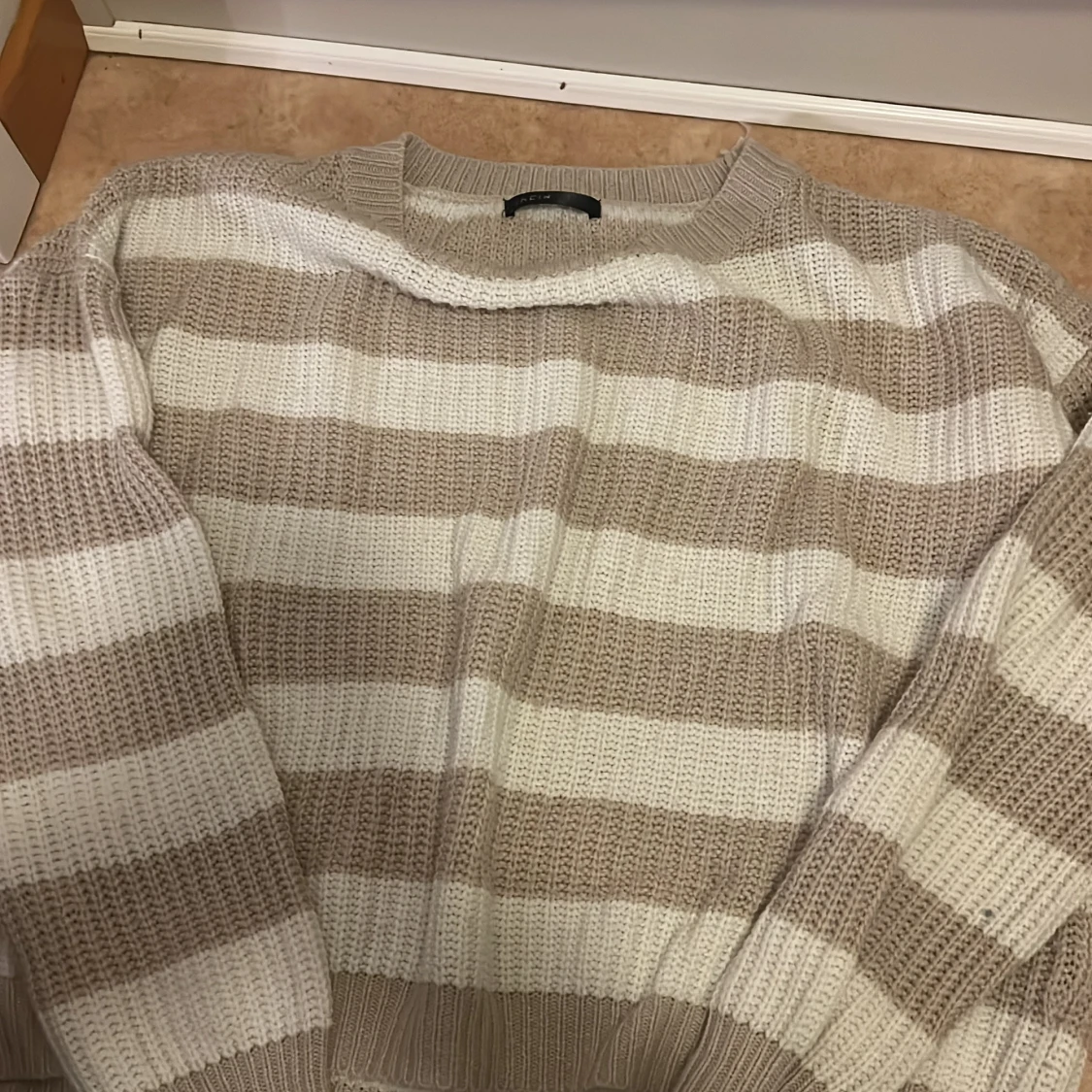 Randig stickad tröja i beige och vitt