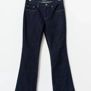 Mörkblå bootcut jeansbyxor - Mörkblå jeansbyxor med klassisk femficksdesign och bootcut-ben. Snygg, enkel look med kontrastsömmar och normal passform. Perfekta för dig som gillar en tidlös stil med lite utsvängda ben.