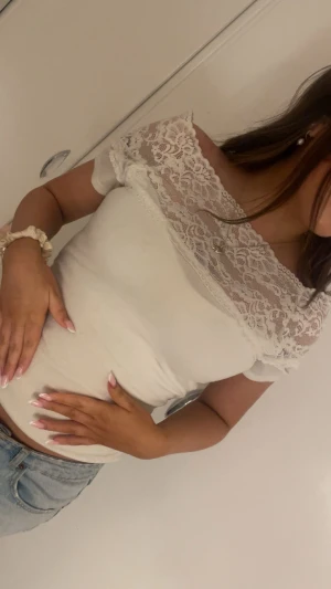 Vit blus med spetsdetaljer - Säljer en söt vit blus med spets upptill som går över axlarna. 