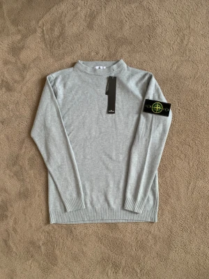 Helt Ny Grå Stone Island Tröja - Säljer denna helt nya Stone Island tröjan i grå färg, perfekt nu inför det kalla vädret❄️  Den är storlek M men skulle säga att den passar mer som S då den är slim fit och materialet är elastiskt  Vid fler frågor eller funderingar skicka gärna ett pm, Mvh