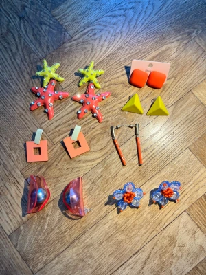 Färgglada statementörhängen, 6 par - Säljer 6 par unika statementörhängen i plast och metall. Inkluderar stjärnformade örhängen i gult och orange med strass, gula trianglar, orange fyrkanter, röda och guldiga stavar, futuristiska rosa med pärla samt blå och orange blommor. Perfekt för dig som vill sticka ut!