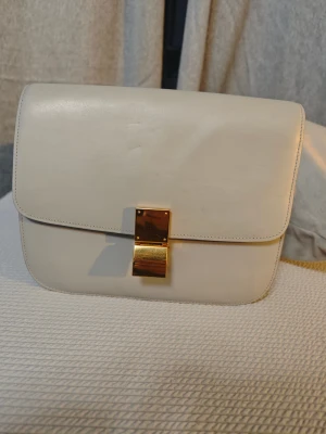 Axelväska - Axelväska i äkta läder med flera praktiska fack. Färg: Light Grey. Använd, med små repor på framsidan enligt bild, men fortfarande i mycket gott skick.