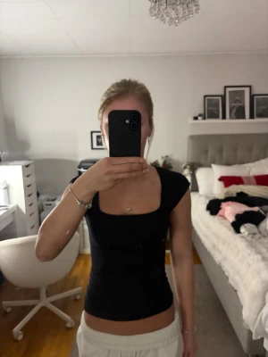 Svart topp med fyrkantig ringning Gina Tricot - Säljer en svart topp från Gina Tricot i storlek XS. Toppen har en snygg fyrkantig ringning och är ärmlös med en tight passform. Tillverkad i mjuk bomull som känns skön mot huden. 