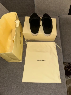 AXEL ARIGATO - Säljer mina Axel Arigato sneakers i svart med vit sula. Skorna är i bra skick och kommer med allt original: 	•	Skokartong 	•	Dust bag 	•	Shopping bag.                                                                      Pris kan diskuteras.
