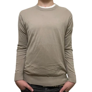 Riley tröja - Snygg beige stickad tröja från Riley med rund hals och ribbade muddar vid ärmslut och nederkant. Tröjan har en clean och stilren look som funkar till jeans eller chinos. Perfekt för dig som gillar enkel och klassisk stil.