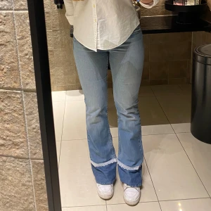 Ljusblåa jeans med spetskant - Med en vit spetskant smälter det tillagda tyget ihop bättre med jeansen och är samtidigt en gullig detalj🥰Man kan se att jeansen är använda men de är ändå i bra skick!! Innerbenslängden är lite kortare för de här, 87 cm!!💙Strl M är en uppskattning så kontrollera att måtten som står i sista bilden stämmer överens med dig😊Hör av dig vid frågor!!