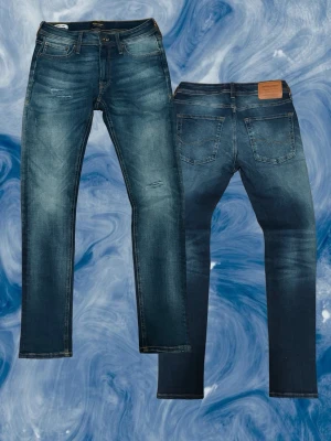 Jack & Jones Skinny Liam jeans blå - Snygga blå jeans från Jack & Jones i modellen Skinny Liam. De har en smal passform, klassisk femficksdesign och slitningar framtill. Jeansen är bra skick 9/10 med storleken 29/30