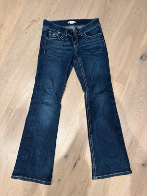 Bootcut jeans från Gina Young, blå, stl 152 - Snygga mörkblå bootcut jeans från Gina Young med kontrastsömmar och detaljerade fickor med knappar både fram och bak. Klassisk dragkedja och knappstängning. Perfekt passform och mjuk skön stretch. Mkt fint skick!