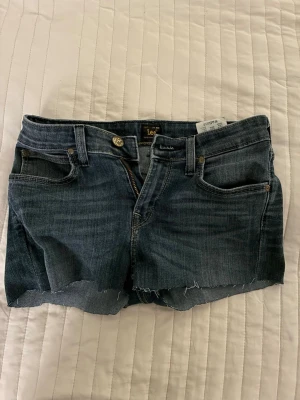 Mörkblå jeansshorts från Lee - Säljer ett par mörkblå jeansshorts.Ingen aning vilken storlek men känns som en Xs/S. Var egentligen Ett par byxor ifrån början som jag klippte av och gjorde om till ett par jenas shorts 