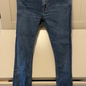 Tiger of Sweden jeans - Snygga blå jeans från Tiger of Sweden i modellen Slight. De har en klassisk femficksdesign, skinny passform och normal midja. Jeansen är tillverkade i bomull och har orangea sömmar för en stilren look. Perfekta för dig som gillar en smal siluett. storlek 29 i midja och 32 i längd. Pris endast 219kr!! Vid snabb affär är priset inte hugget i sten🪨🤝