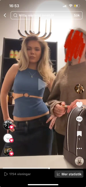 Blå croppad linnetopp med ringdetalj - Säljer en blå croppad linnetopp med en snygg ringdetalj framtill och cut-out under bysten. Toppen är ärmlös och har en tight passform som framhäver midjan. Perfekt för dig som gillar trendiga och unika plagg.