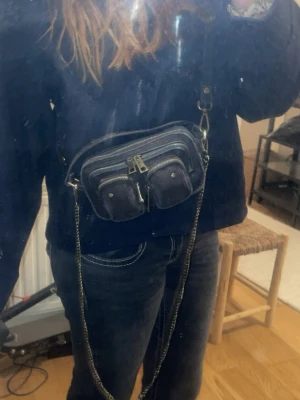 Väska från Nunoo - En liten väska med Manchester tyg och guldrostiga detaljer. 