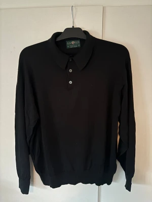 Alan Paine pike - Svart populär finstickad Alan Paine pike i superfint skick, som ny! Inga hål eller fläckar och storlek 54 men sitter som 50/52. Galet exklusivt och elegant plagg!