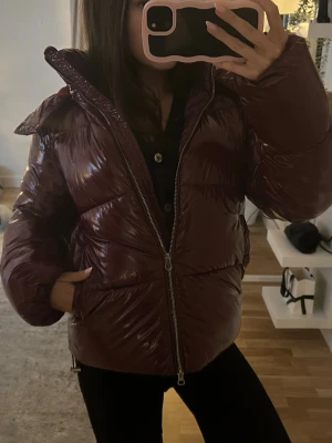Vinröd pufferjacka från Nelly  - Säljer min shiny puffer jacket från Nelly, använd förra vintern men super bra skick! 💕💕