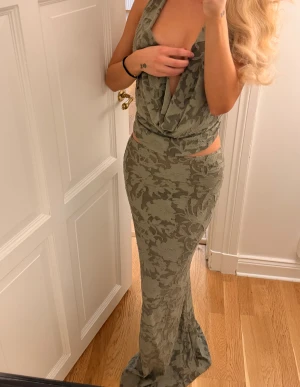 Grön långkjol med matchande top - Säljer en snygg grön långkjol med blommigt mönster och en tillhörande matchade top. Settet är från pretty little thing, använt en gång.