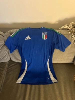 Italien fotbollströja Adidas blå ( S) - Blå officiell Italien fotbollströja från Adidas. Köpt på Unisport för ca 900 rabatterad. Knappt används och skulle beskriva den som ny.  