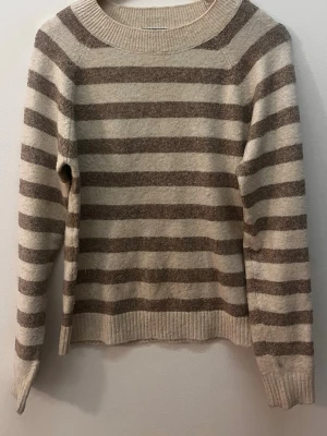 Randig tröja från Vero Moda - Säljer en mysig stickad randig tröja från Vero Moda i storlek XS. Tröjan är jätteskön och mjuk på!🤎