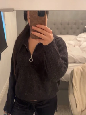 Mörkgrå stickad tröja med half zip - Säljer en mörkgrå stickad tröja med half zip och rund metallring på dragkedjan. Använd fåtal gånger och inga defwktwr alls!
