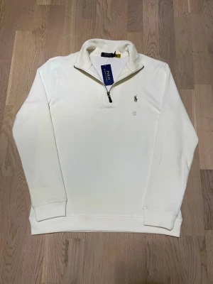 Polo Ralph Lauren Half Zip Sweater - Stilren och exklusiv Polo Ralph Lauren half-zip sweatshirt i en elegant cremefärgad ton. Ett tidlöst plagg som kombinerar klassisk design med hög kvalitet – perfekt för dig som vill ha en ren och sofistikerad look.  • Märke: Polo Ralph Lauren • Typ: Half-zip sweatshirt • Färg: Cremefärgad • Passform: S-M • Skick: Mycket fint skick • Mjuk och bekväm kvalitet • Klassisk broderad Polo-logga på bröstet  Hör av dig vid intresse, pris kan diskuteras!😊