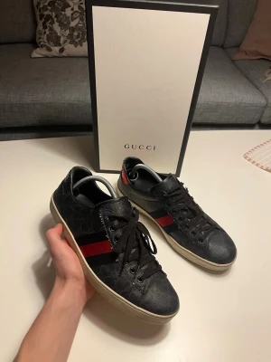 Gucci ace  - Snygga svarta Gucci ace i hyfsat skick! Size 9,5 passar 43, kommer med box och kort. Pris 1700kr!! Nypris 8000kr