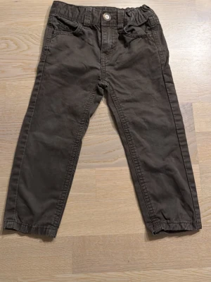 Bruna chinos från Esprit, strl 92 - Säljer ett par bruna chinos från Esprit i mjuk bomull. Byxorna har normal passform, klassiska fickor fram och bak samt hällor för bälte. Stängs med knapp och dragkedja. Perfekta till vardagslooken!
